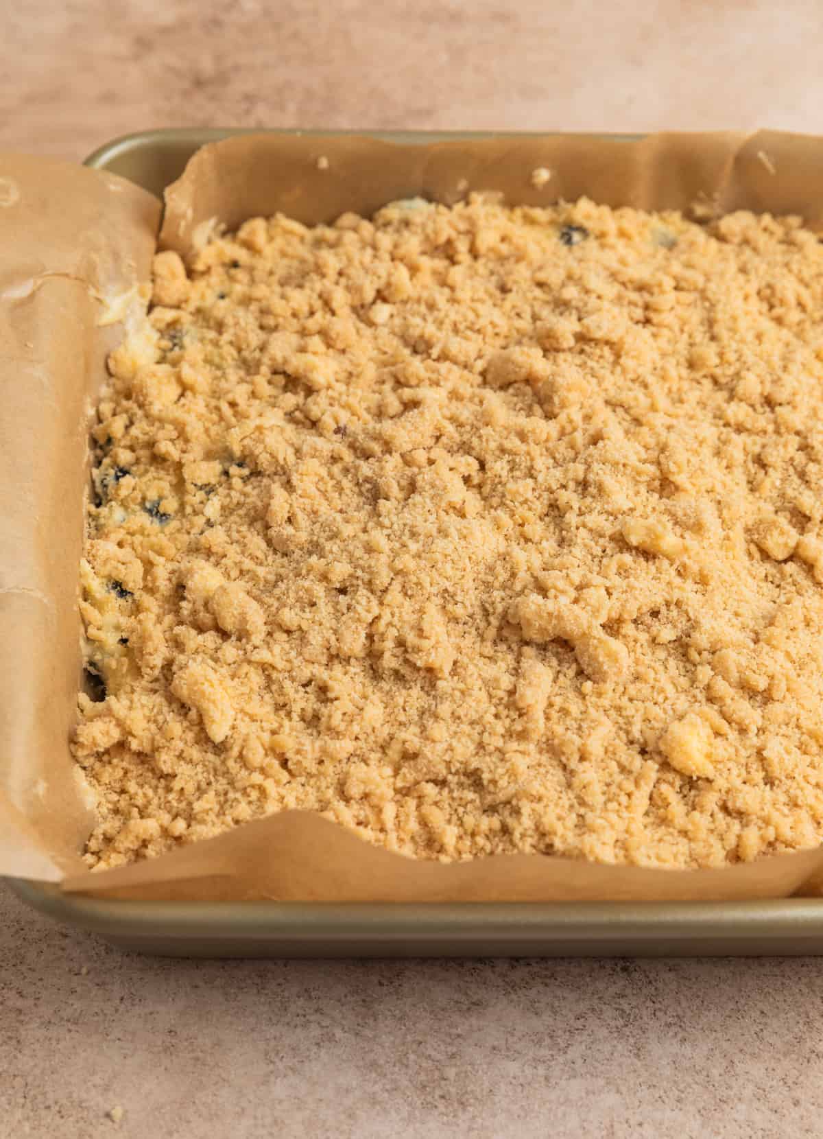 Streusel added to top of coffee cake batter in pan.