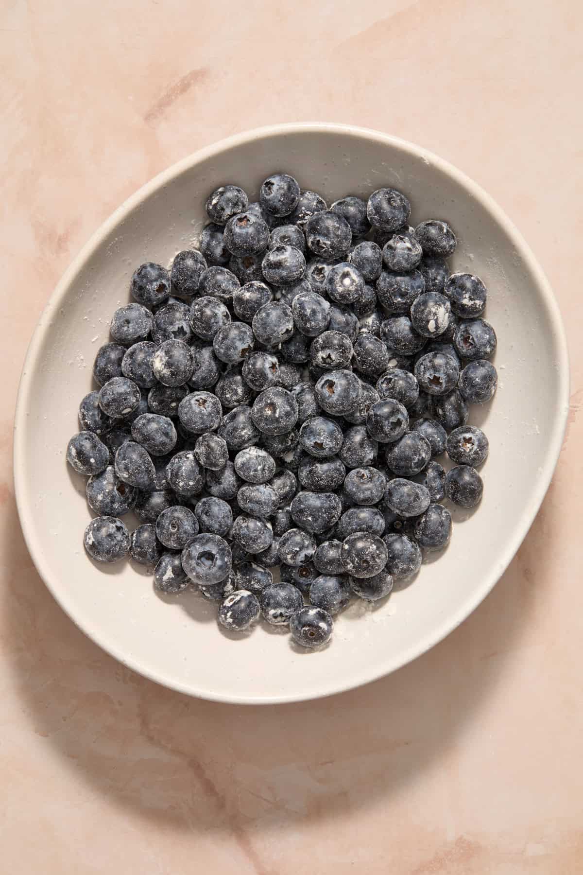 Blueberries tossed with flour in bowl.