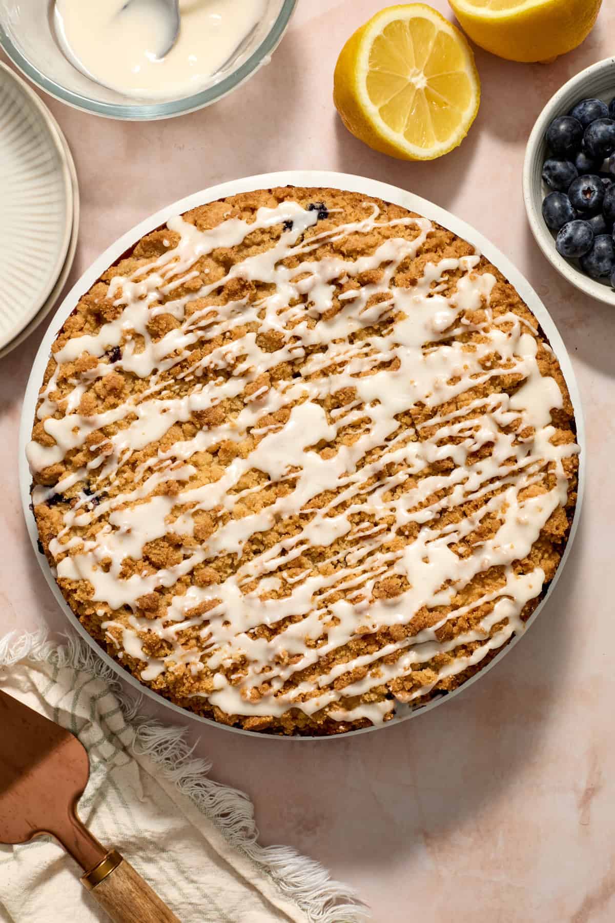 Drizzled lemon icing over top of blueberry coffee cake.
