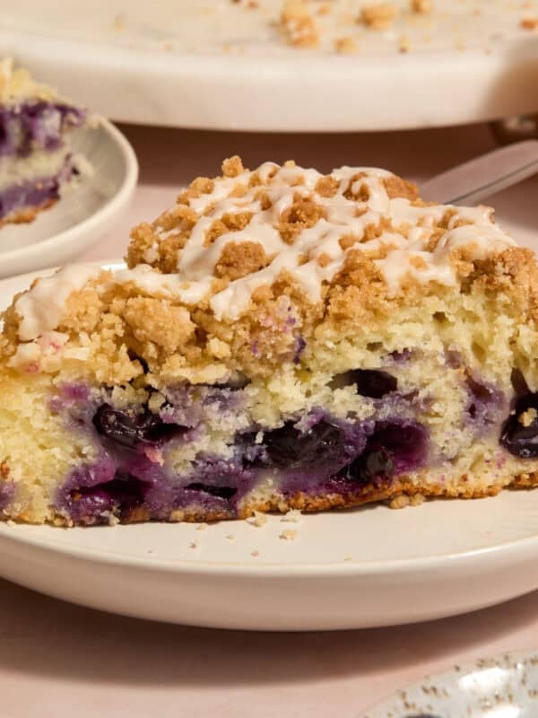 Slice of blueberry lemon coffee cake on plate with icing drizzle on top.