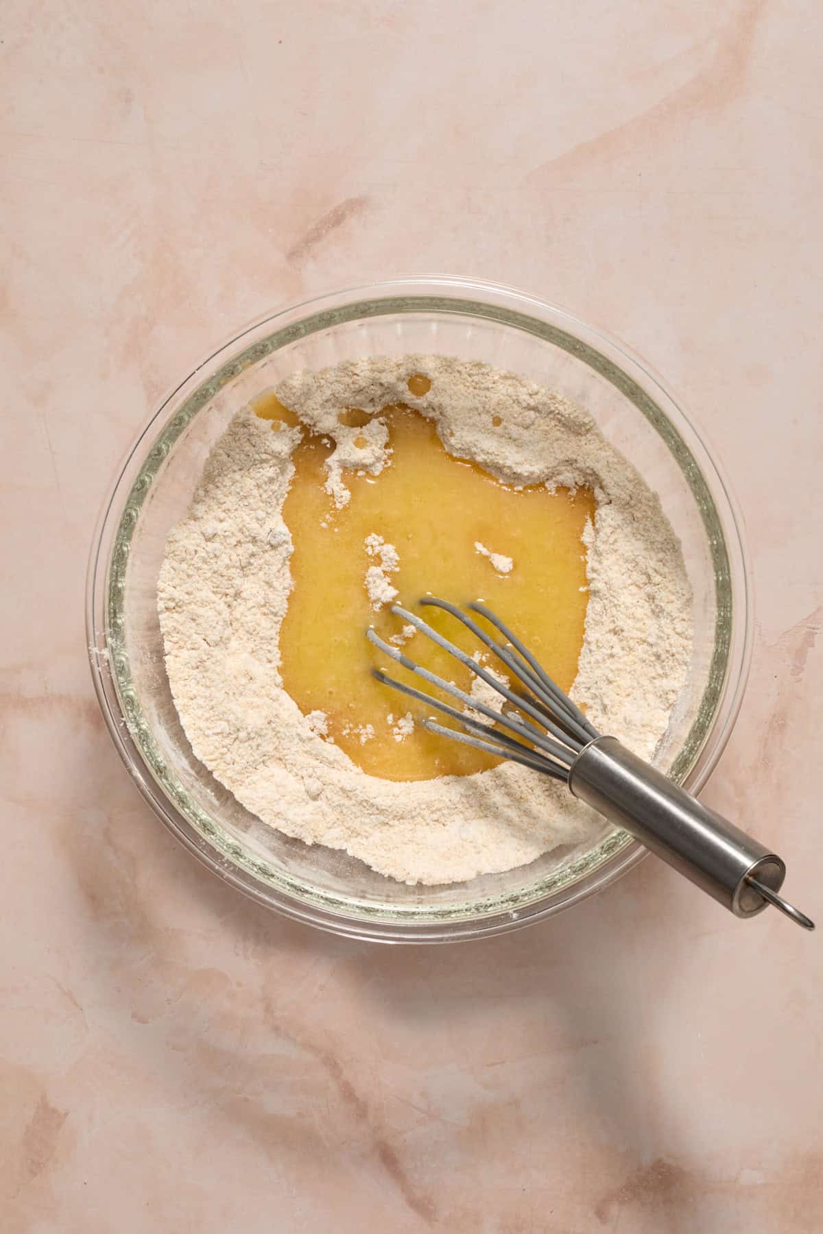 Melted butter added to dry ingredients in bowl.