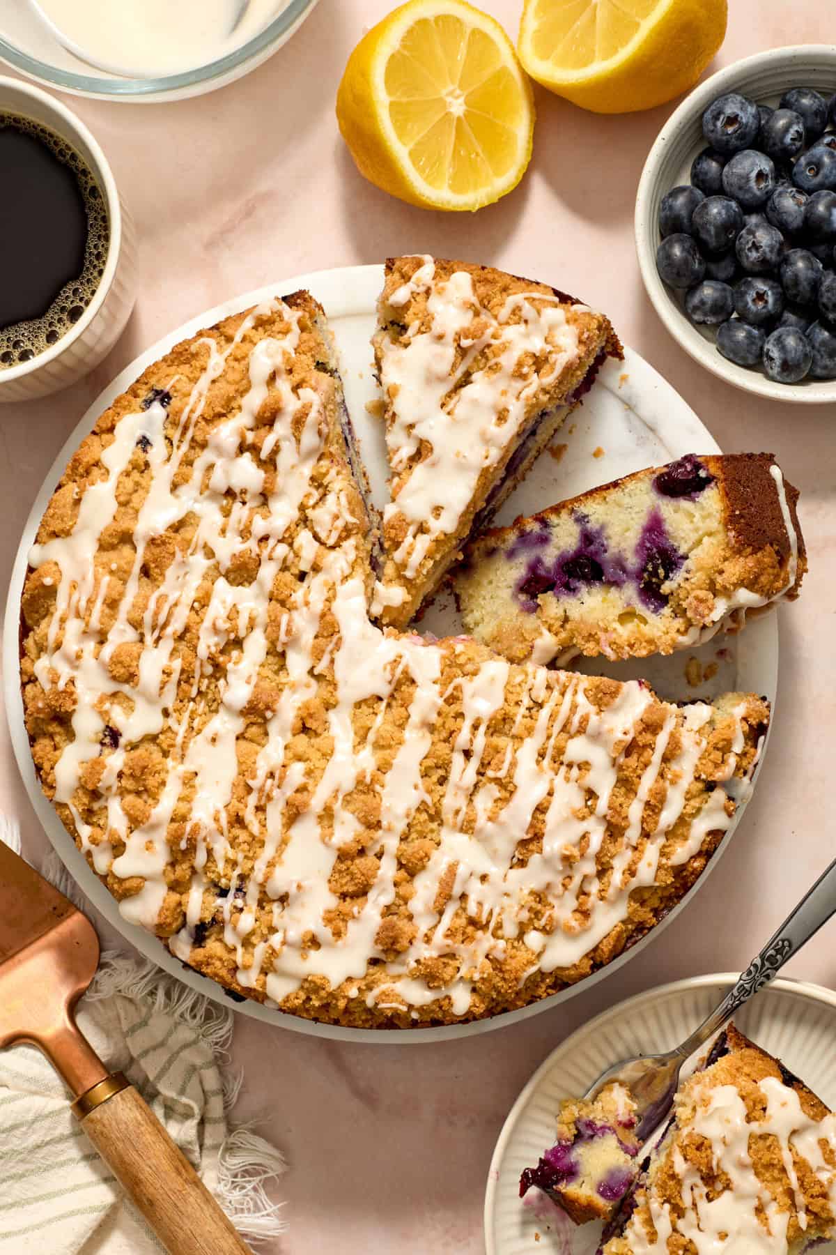 Overhead view of blueberry lemon coffee cake with one slice propped on its side.