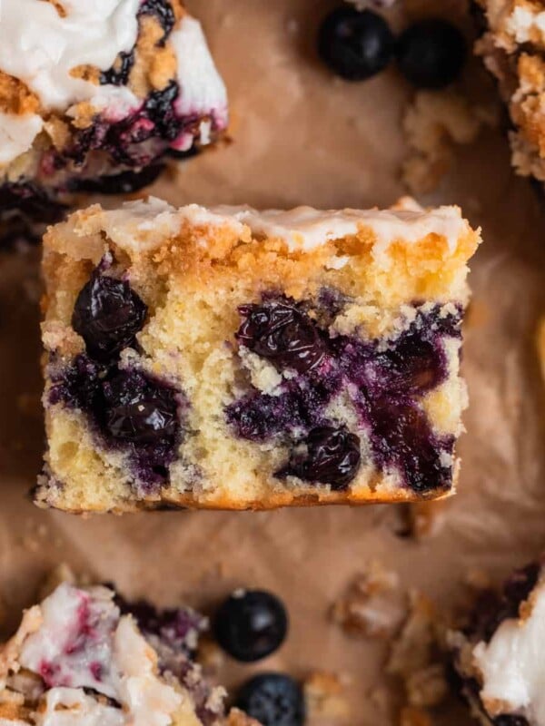 Slice of blueberry lemon coffee cake with streusel topping laid on its side to show texture.