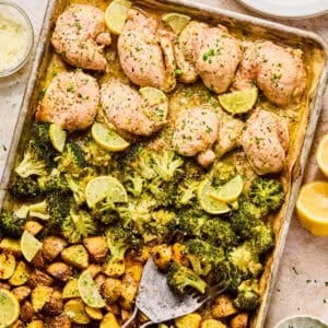 Lemon chicken sheet pan dinner on baking sheet with spatula.