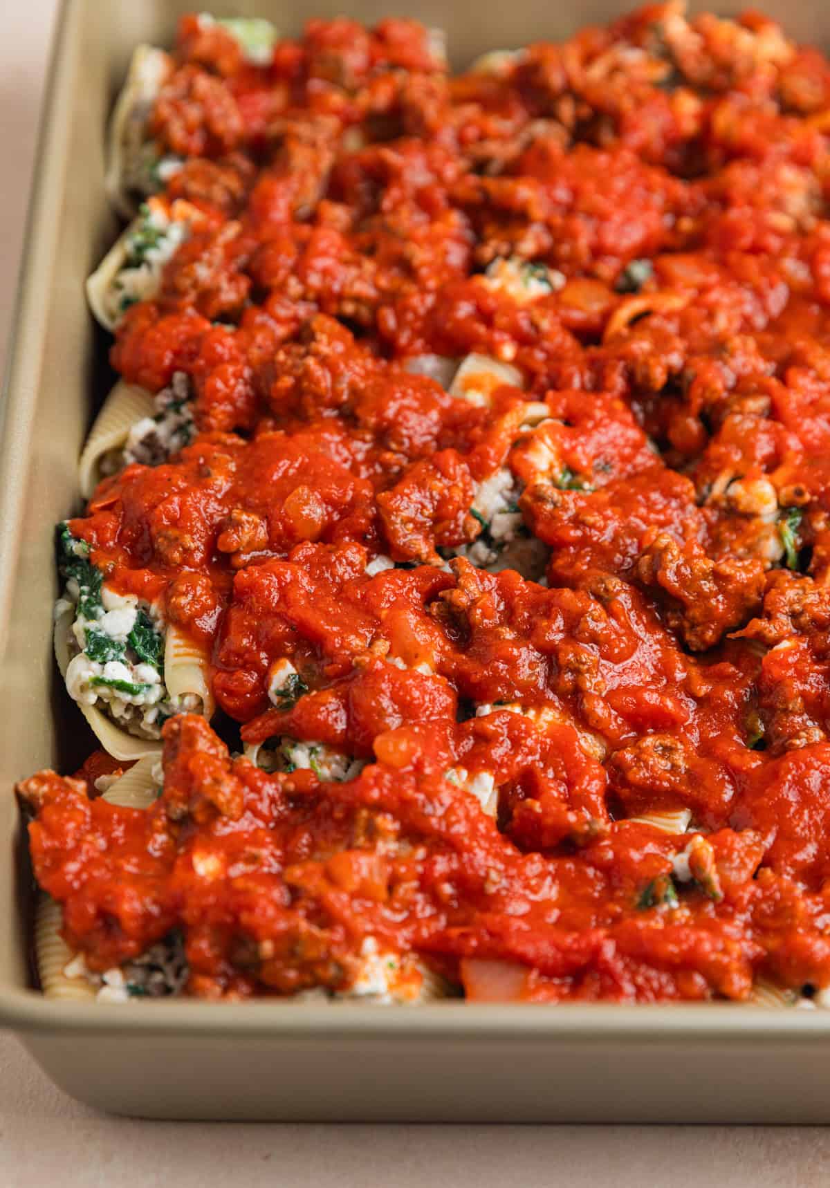 Meat sauce over top of beef stuffed shells before baking.