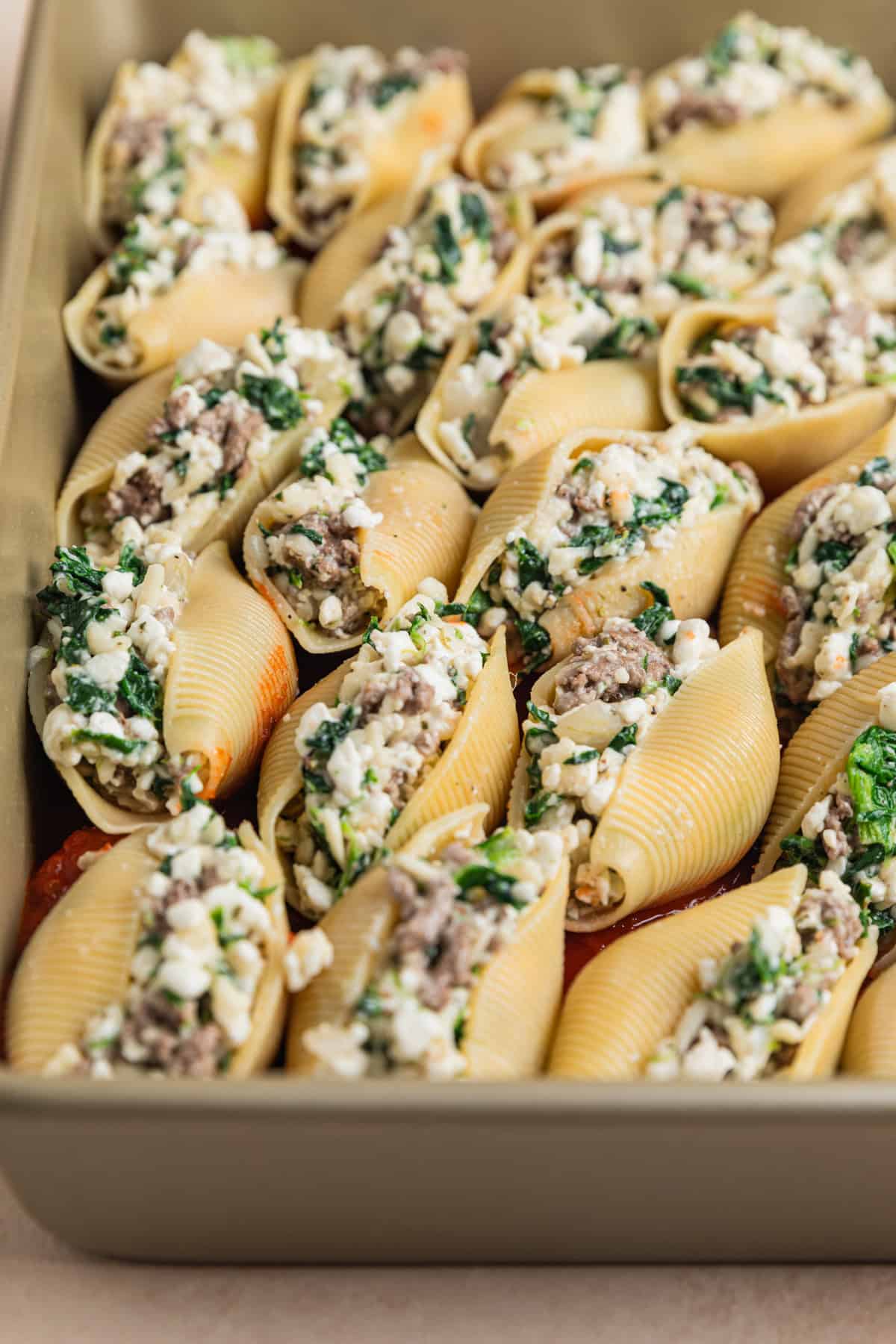 Spinach, cheese and beef stuffed shells in pan before baking.