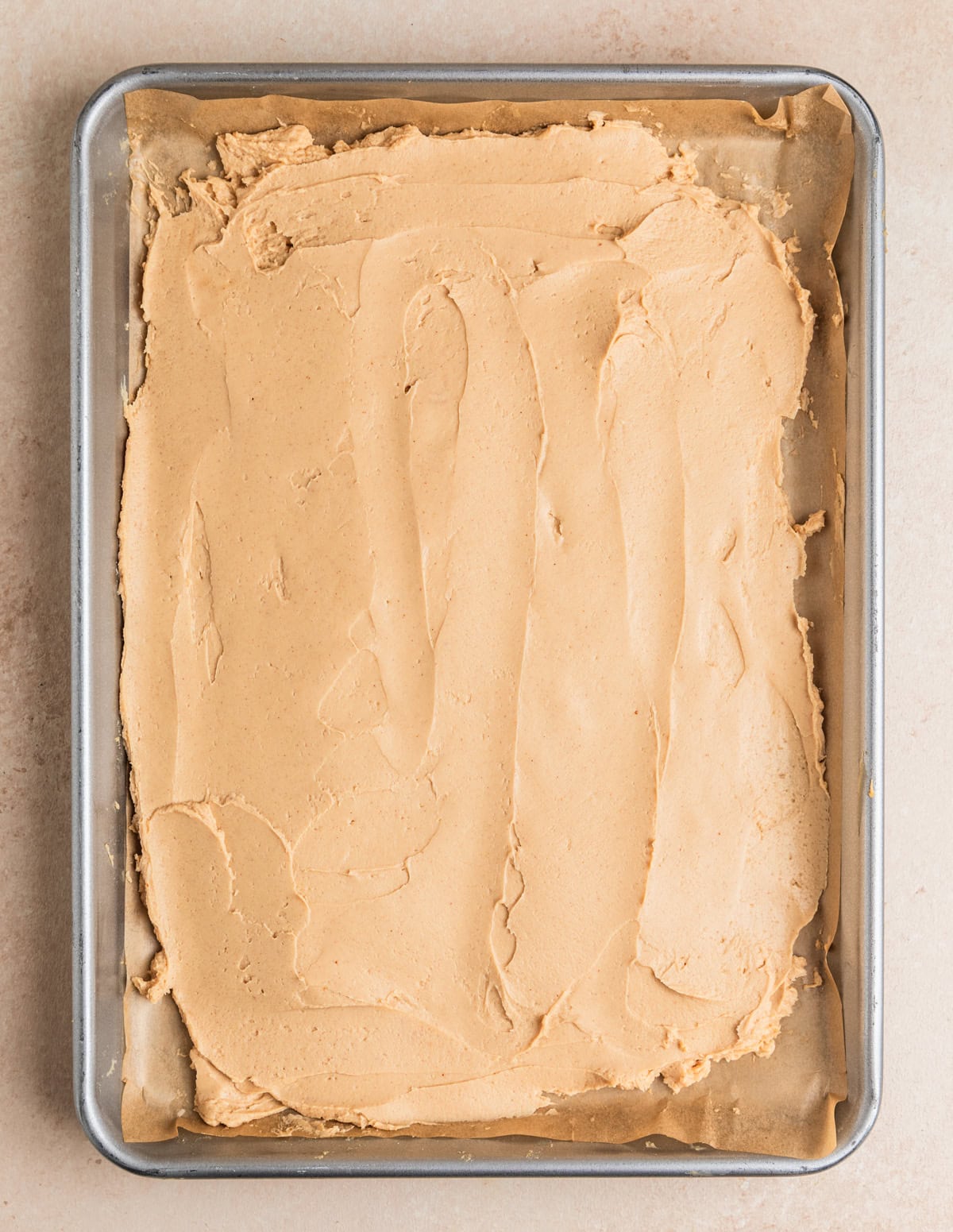 Peanut butter and Greek yogurt mixture spread onto parchment lined baking sheet.