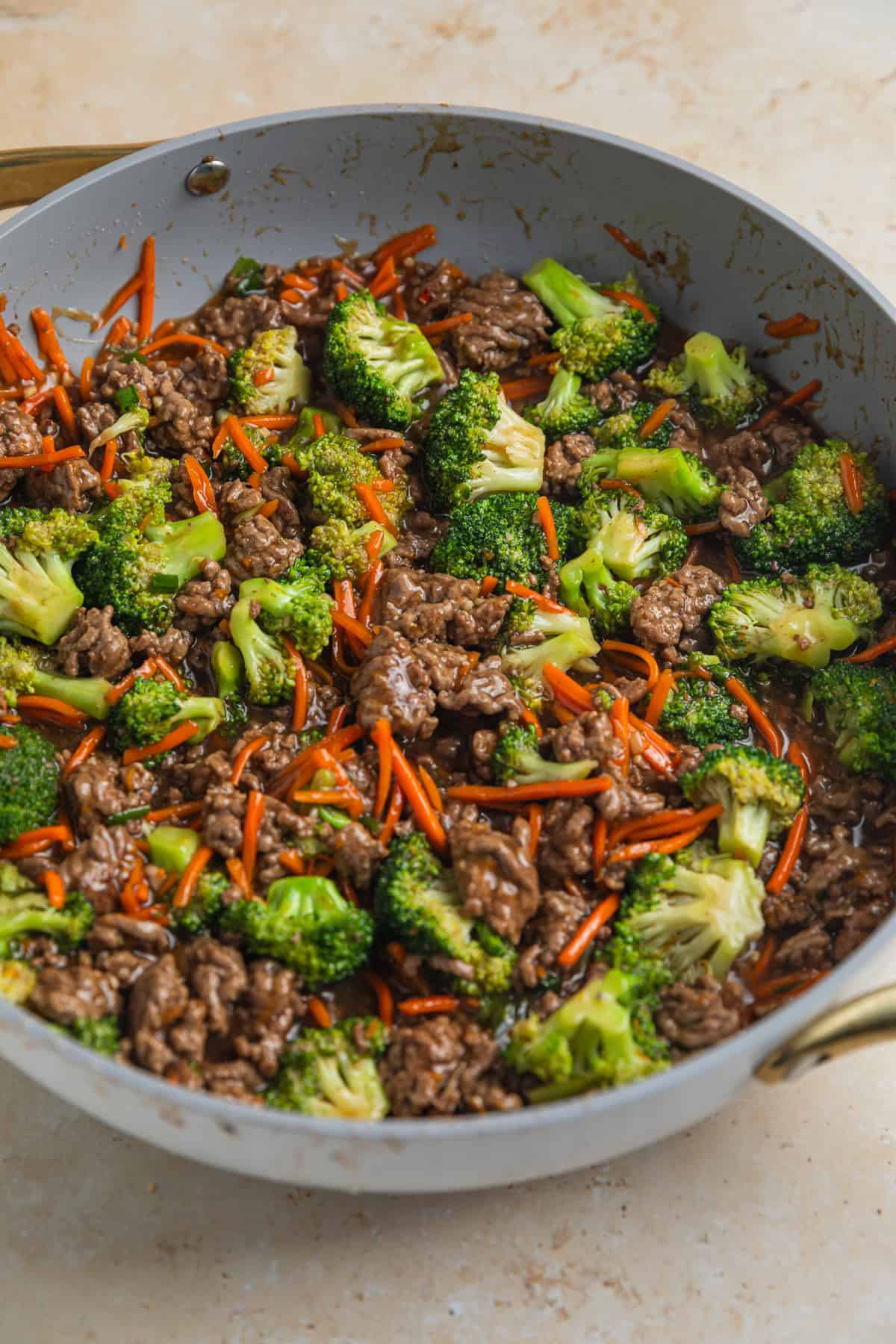 Teriyaki sauce added to skillet with beef and vegetable stir fry.