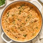 Pan with orzo and chicken cooked in tomato sauce.