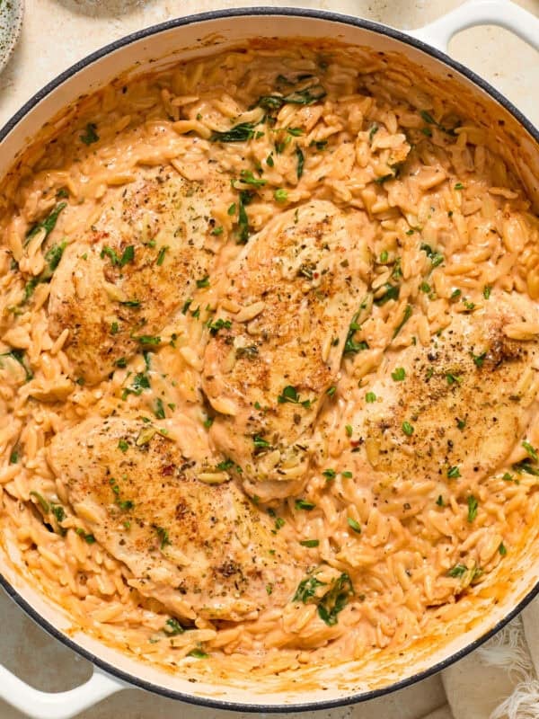 Pan with orzo and chicken cooked in tomato sauce.