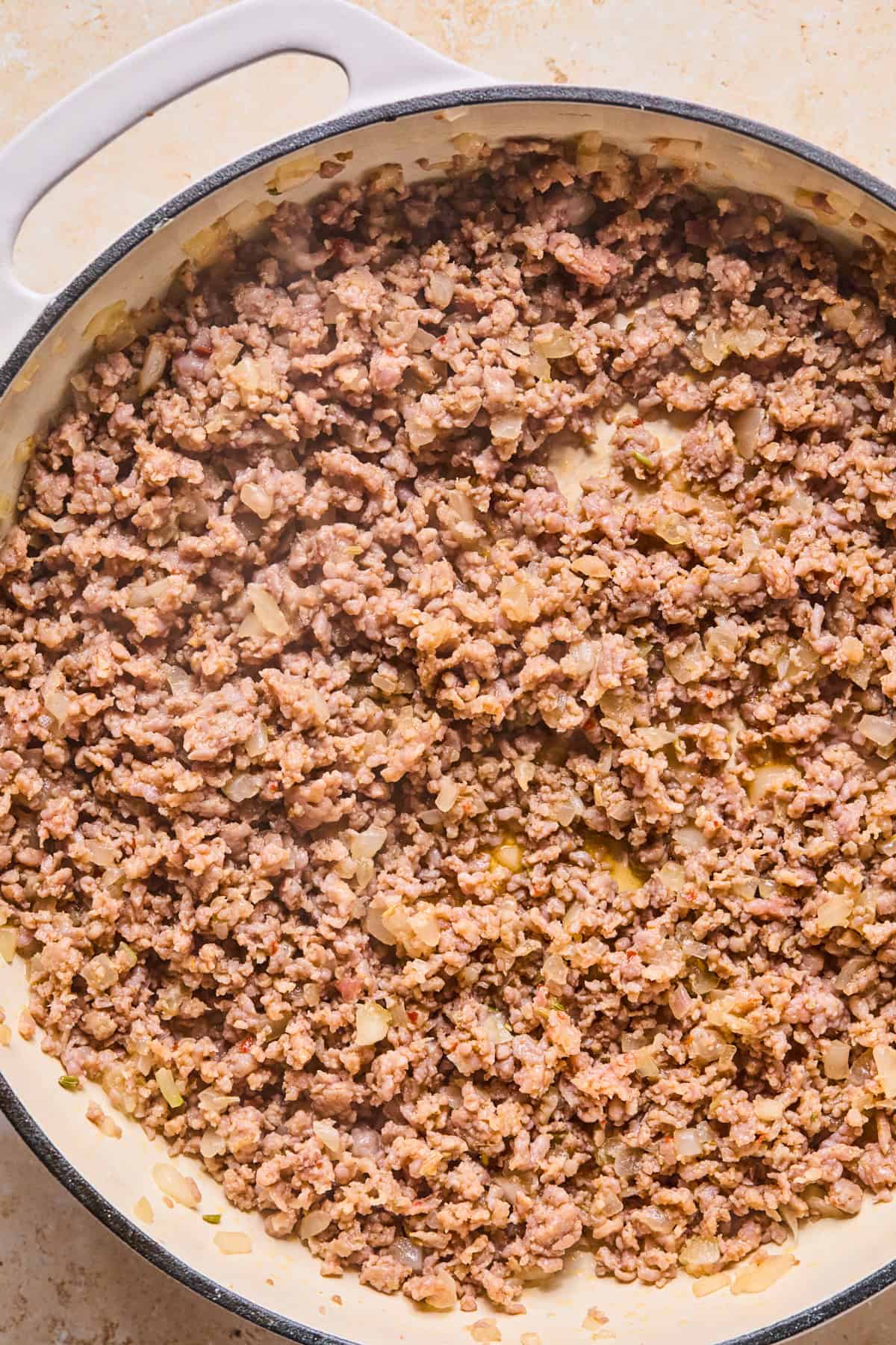 Italian sausage and onions browned in skillet.