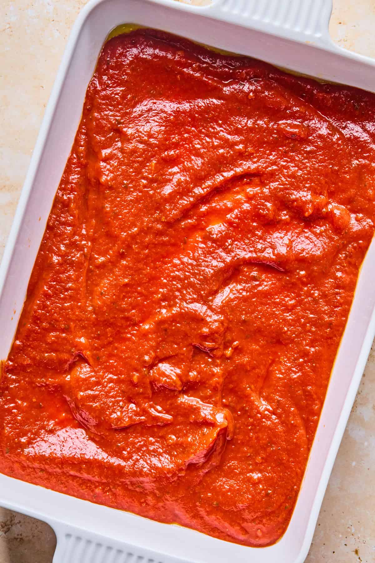 Marinara spread on the bottom of pan.