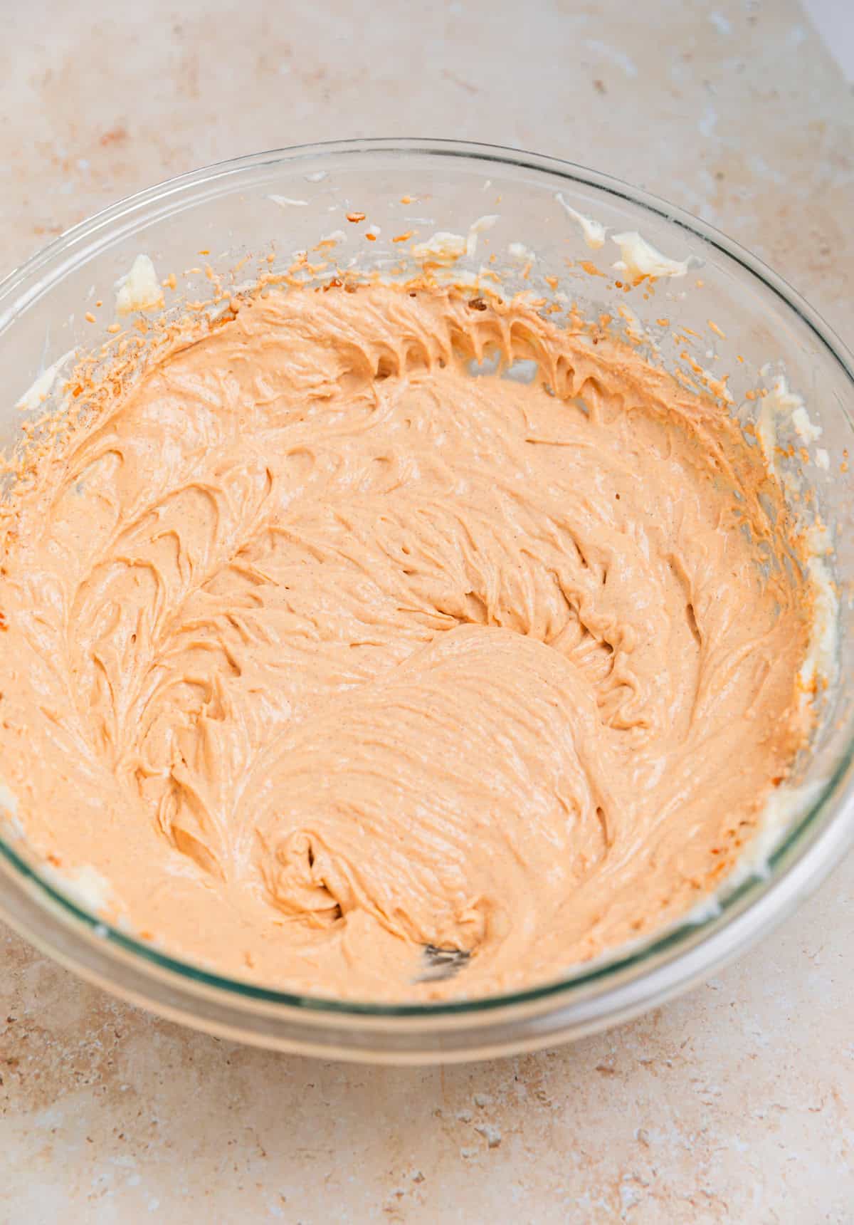 Pumpkin no bake cheesecake filling prepared in glass bowl.