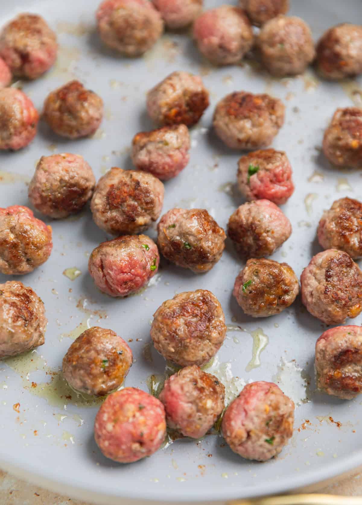 Seared meatballs in pan.