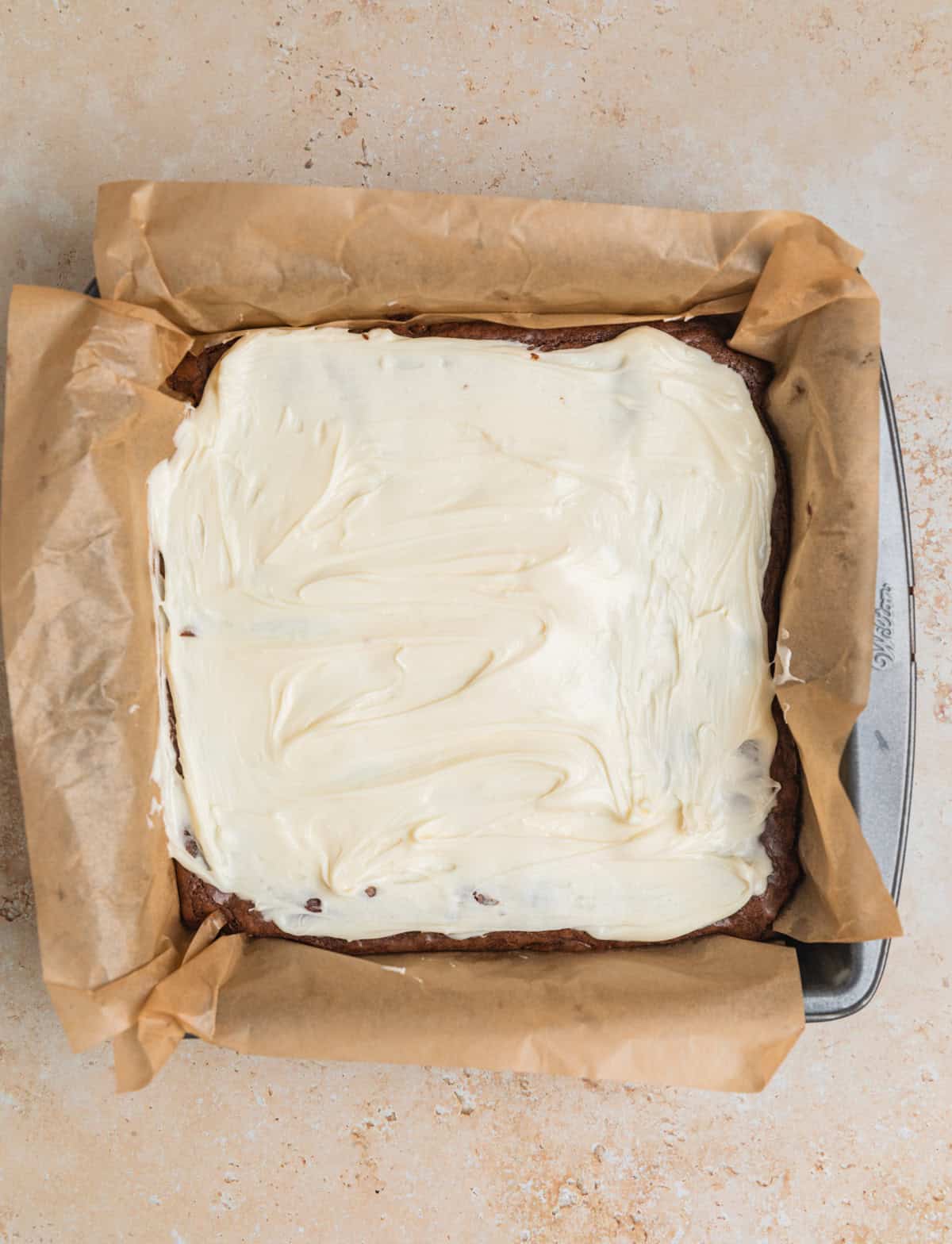 Peppermint white chocolate mixture spread over brownies.