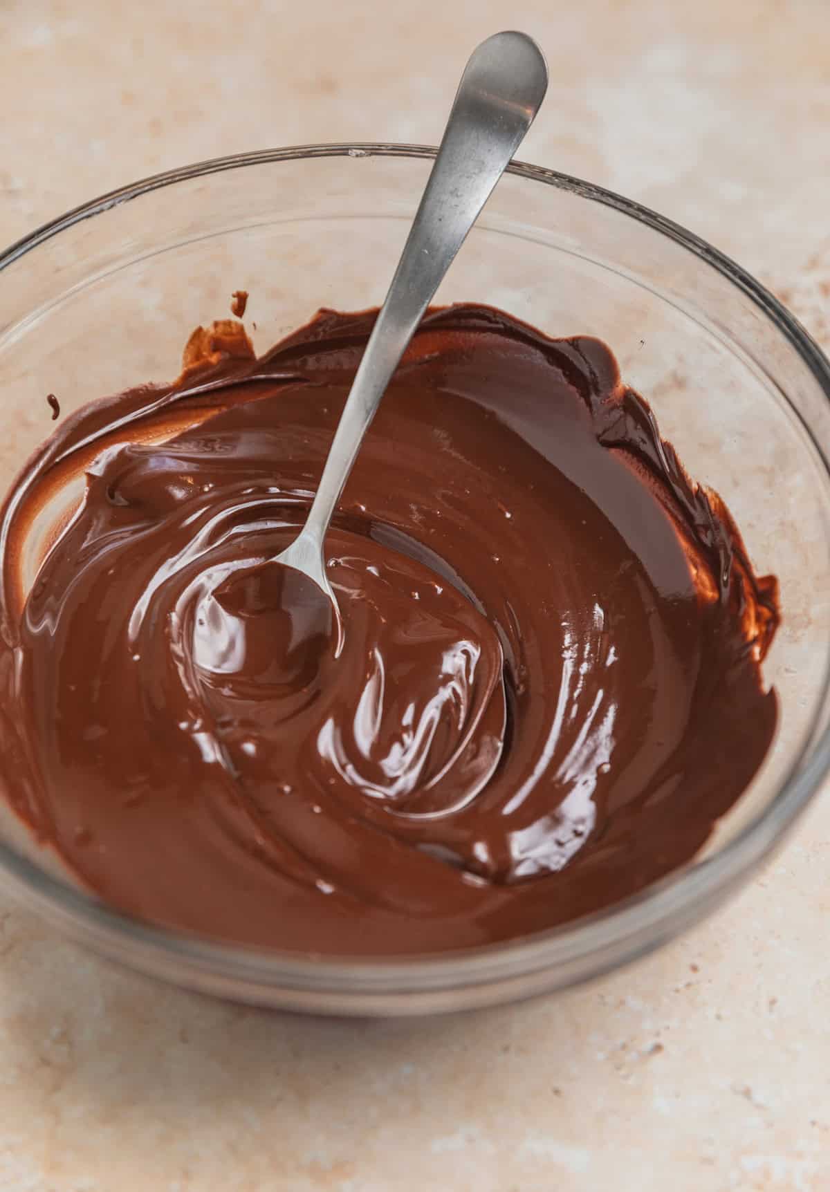 Melted chocolate in bowl with spoon.