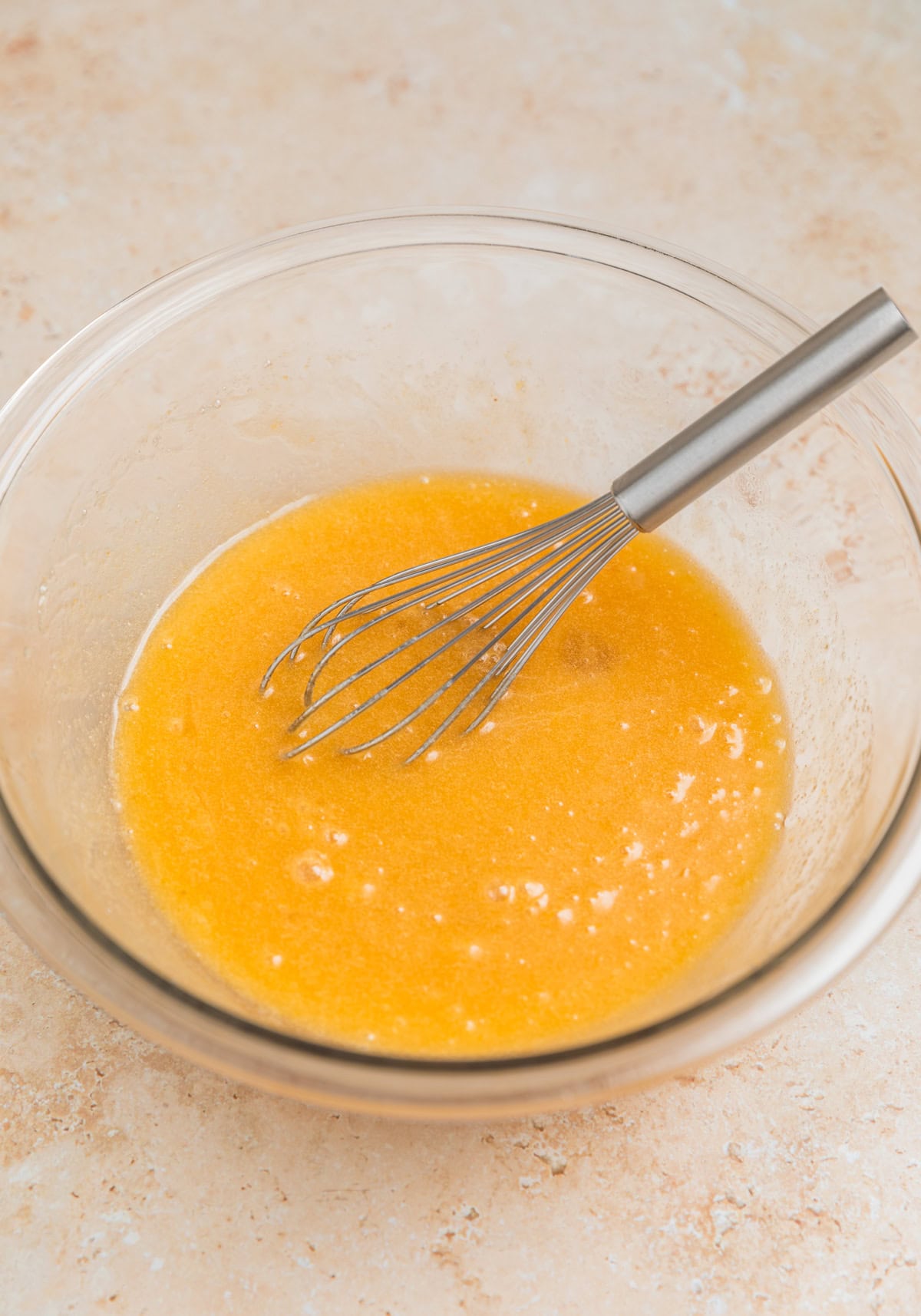 Whisk in bowl with wet ingredients of brownies.