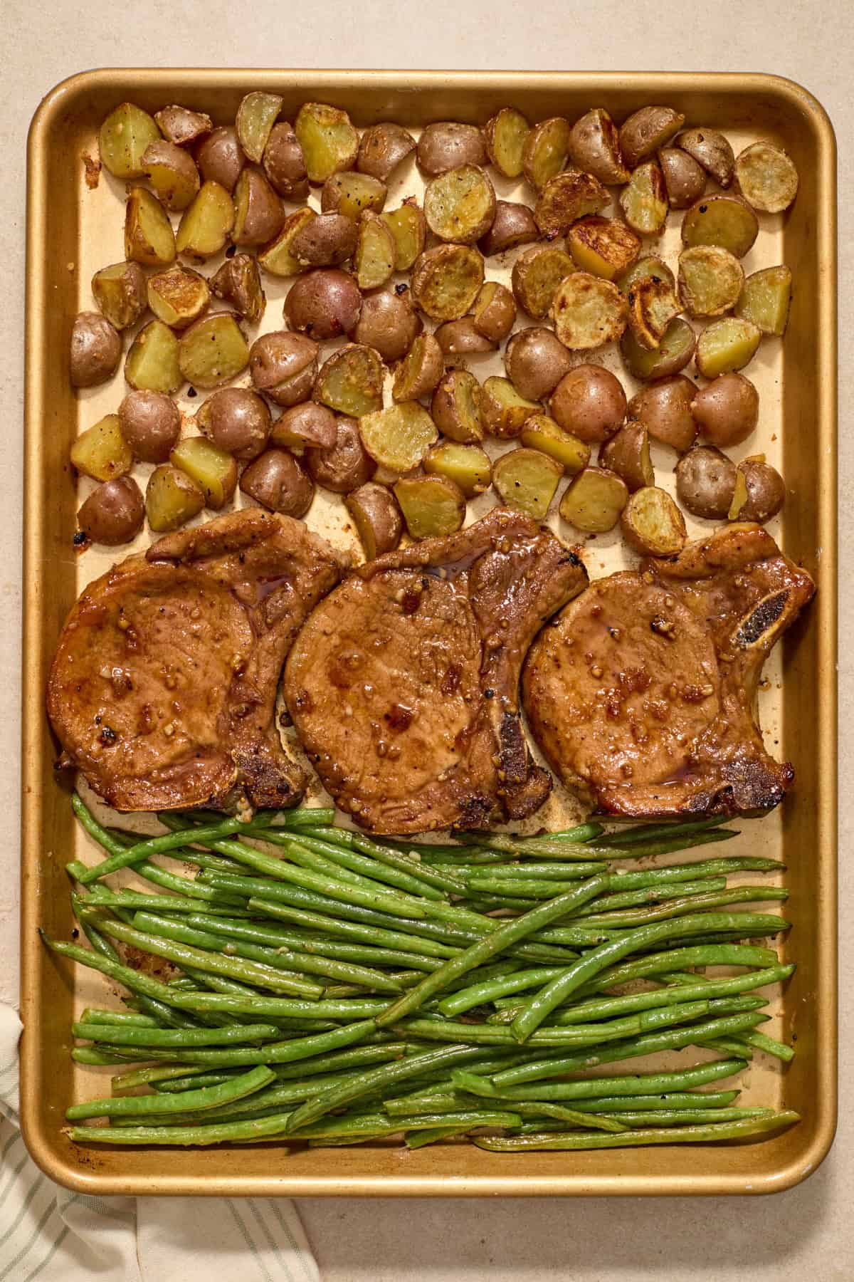 Sheet pan pork chops with potatoes and green beans cooked.