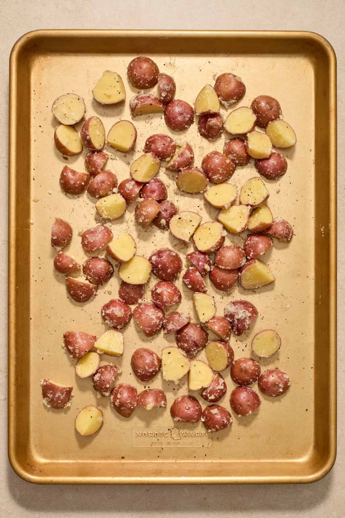 Red potatoes spread on sheet pan.
