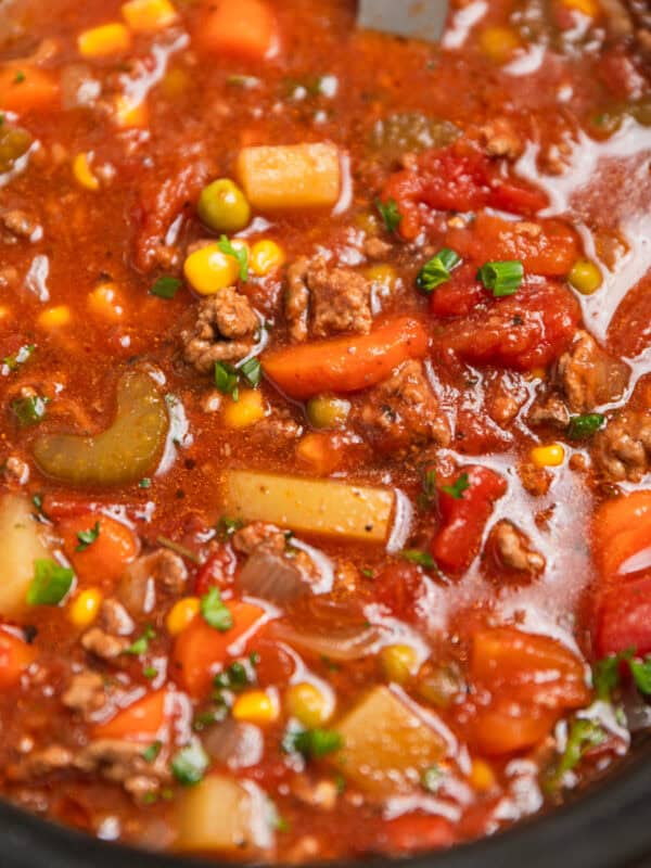 Hamburger soup in slow cooker with ladle scooping into it.