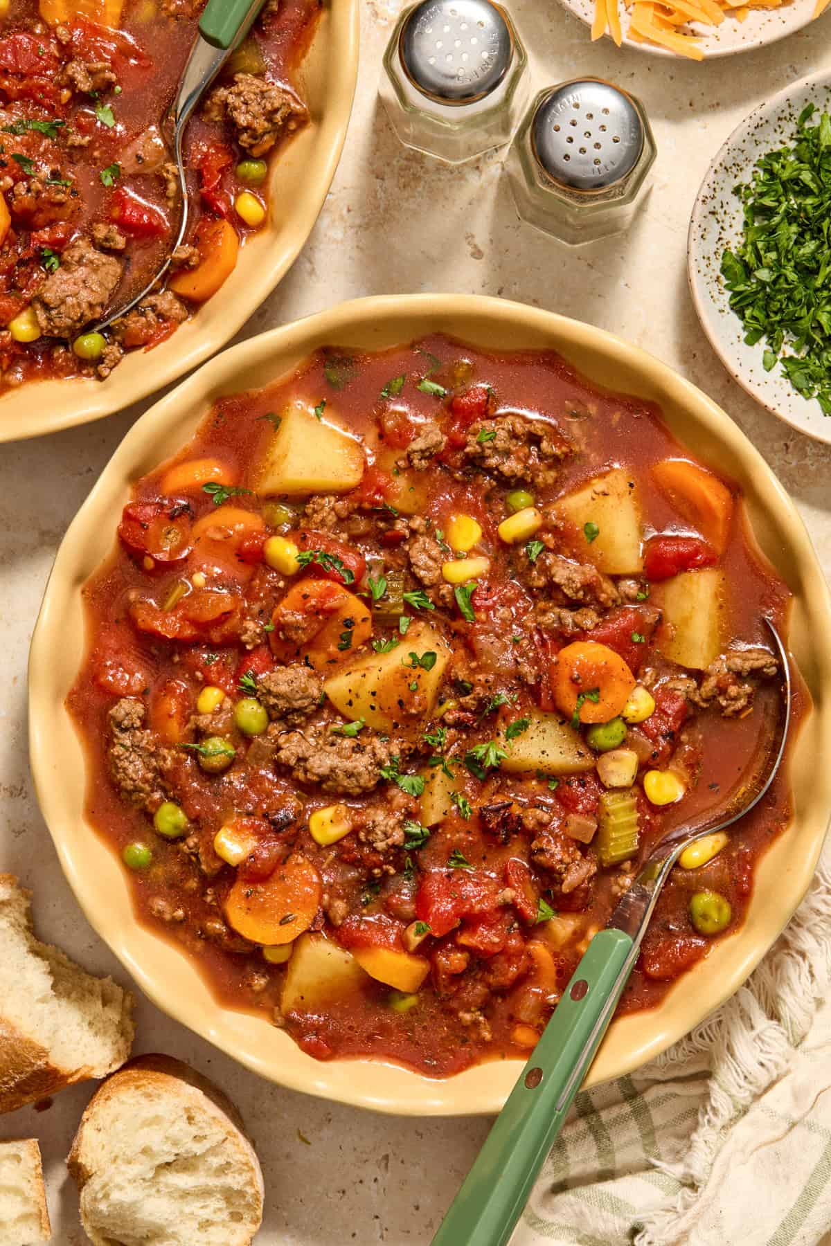 Crockpot hamburger vegetable soup in bowl with spoon.