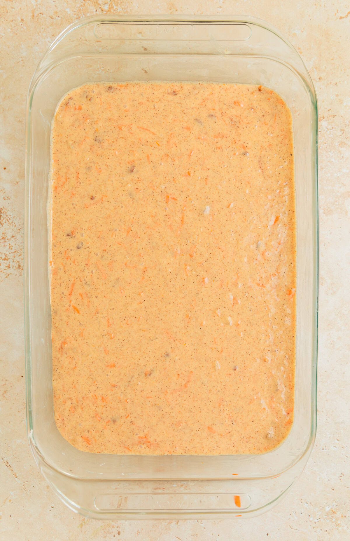 Carrot cake batter in greased glass pan.