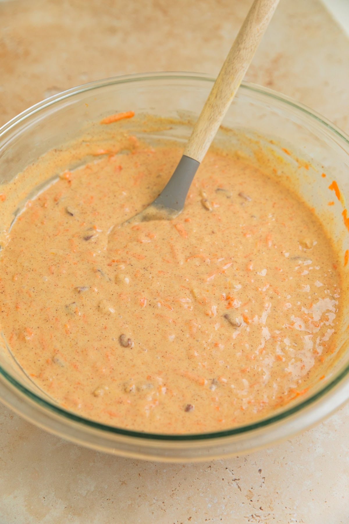 Carrot cake batter mixture made from cake mix in bowl with spoon.