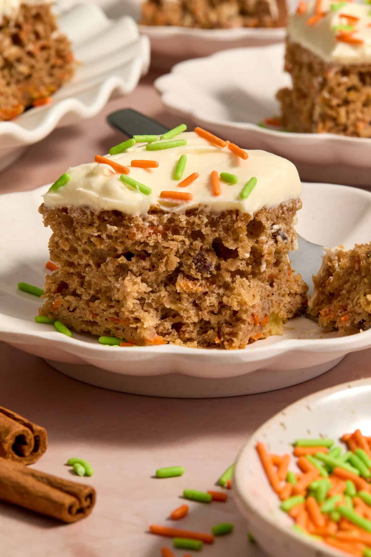 Slice of cake mix carrot cake with cream cheese frosting on plate.