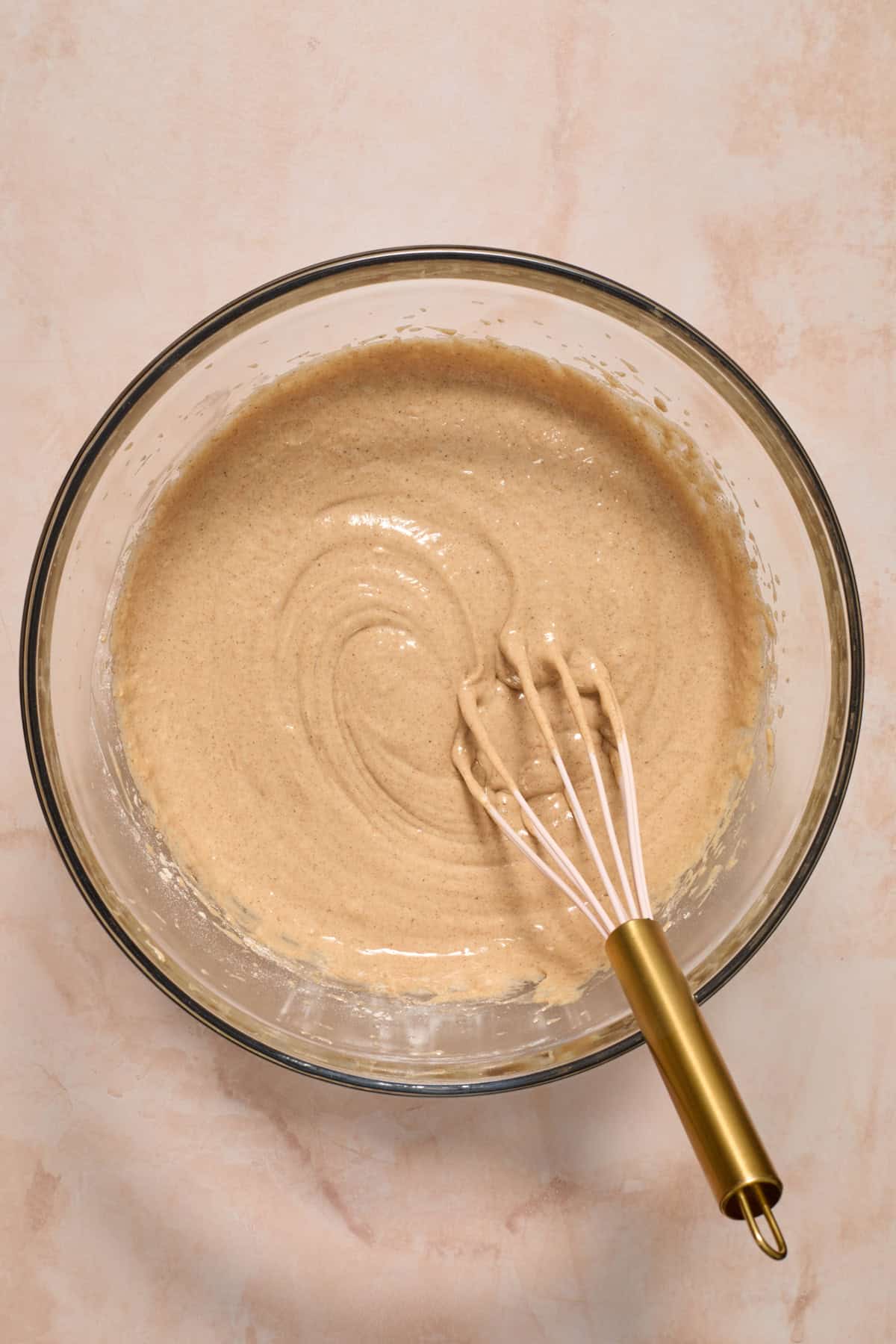 Carrot cake batter mixture in bowl with spoon before adding carrots.