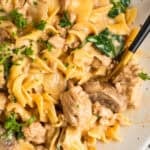 Plate with one pot ground turkey stroganoff served with egg noodles and fork scooping in.