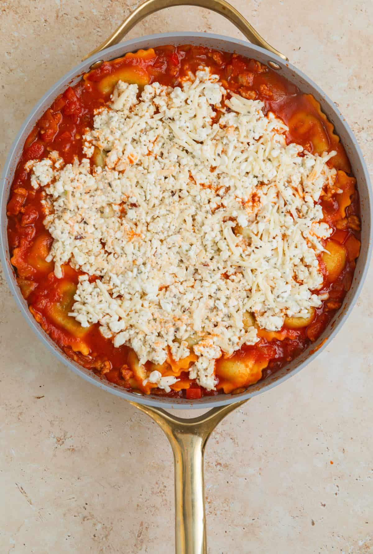 Cottage cheese lasagna mixture spread over top of lasagna in skillet.