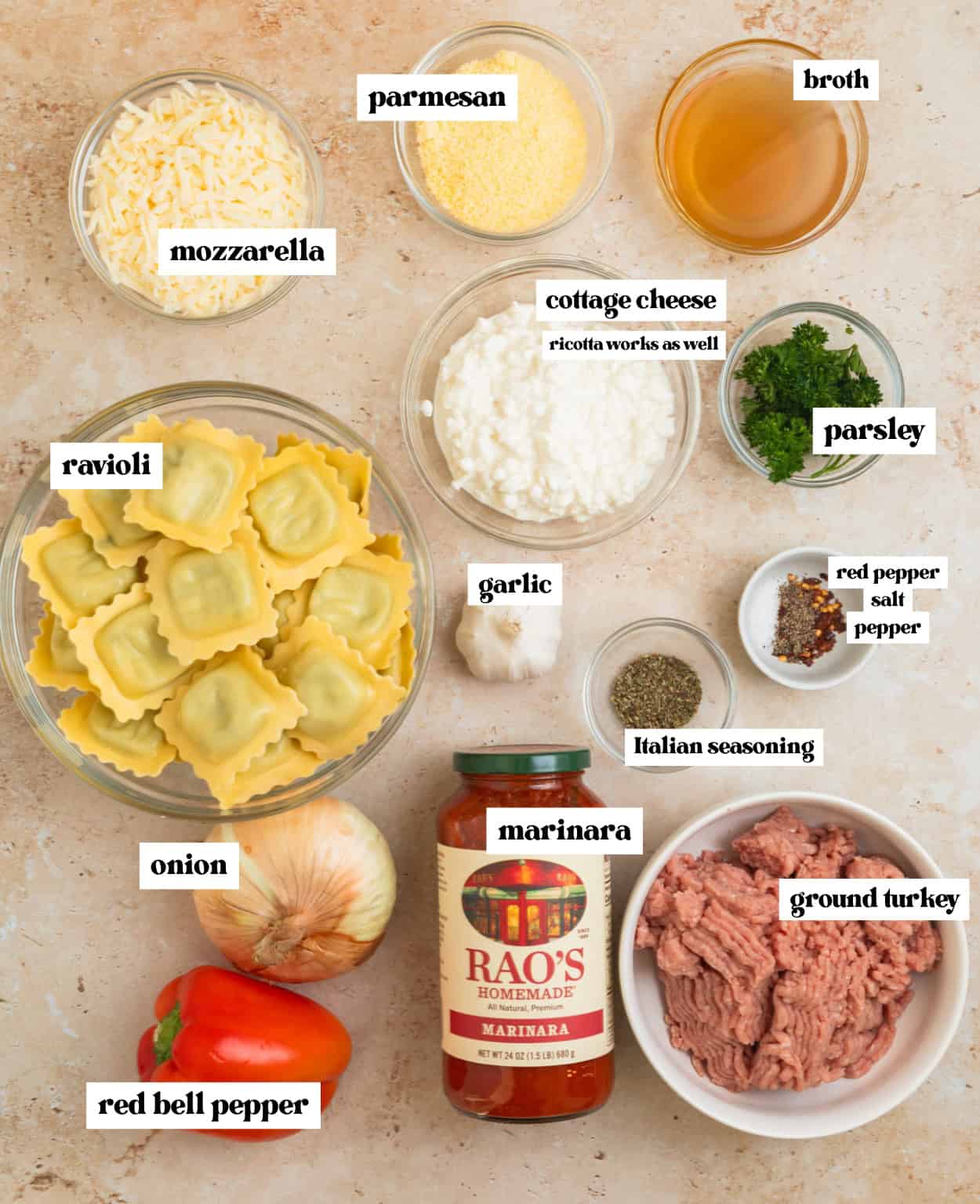 Cheese, ravioli, ground turkey, seasoning and other ingredients arranged on surface.