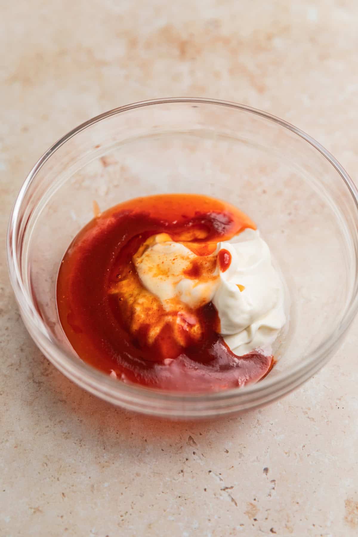 Mayo, sweet chili sauce, sriracha and honey in glass bowl.