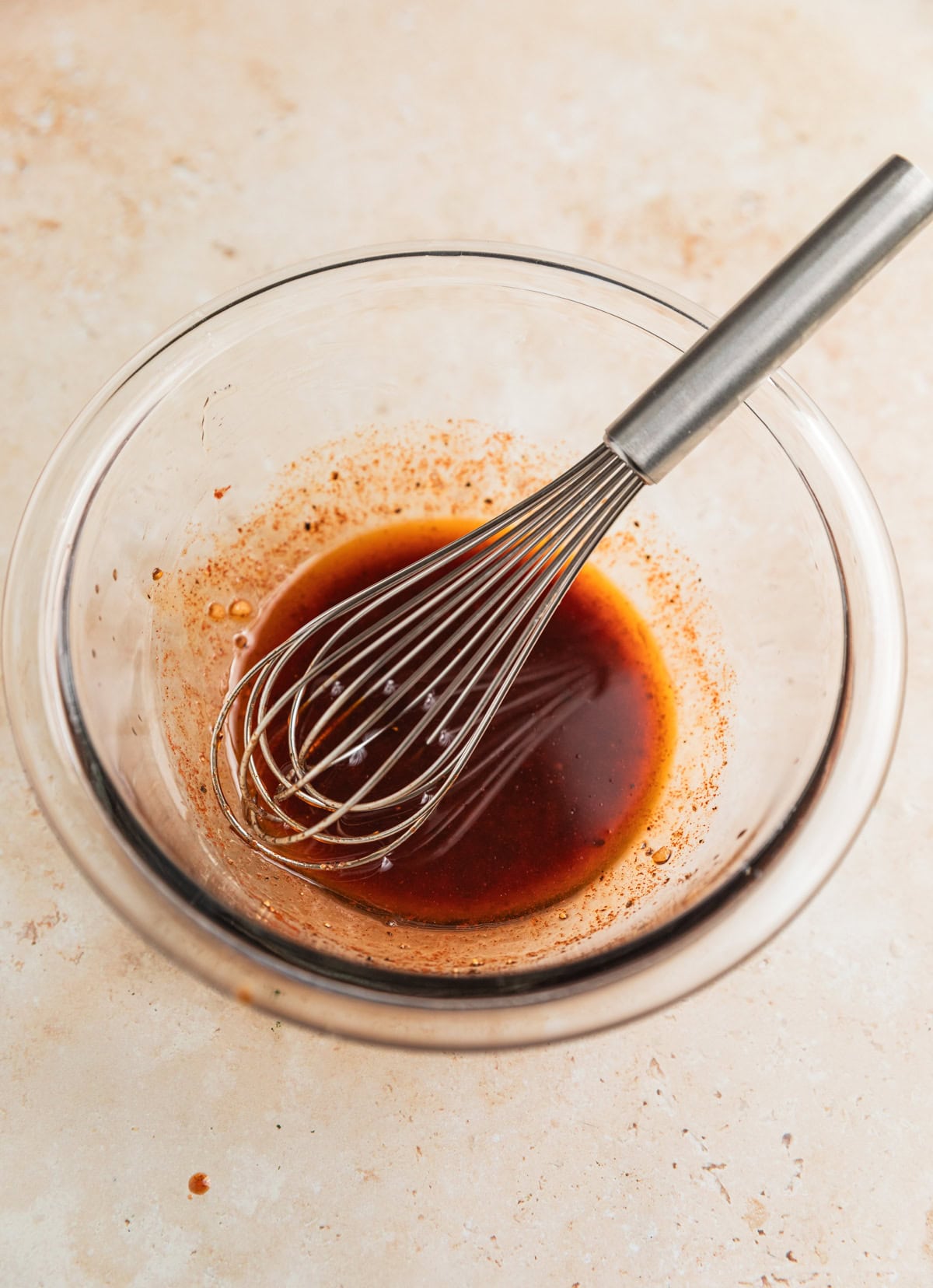 Salmon marinade in glass bowl with whisk.
