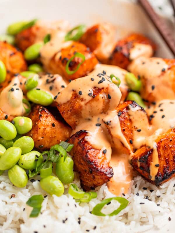 Air fryer salmon bites served with bang bang sauce over top and served on rice.