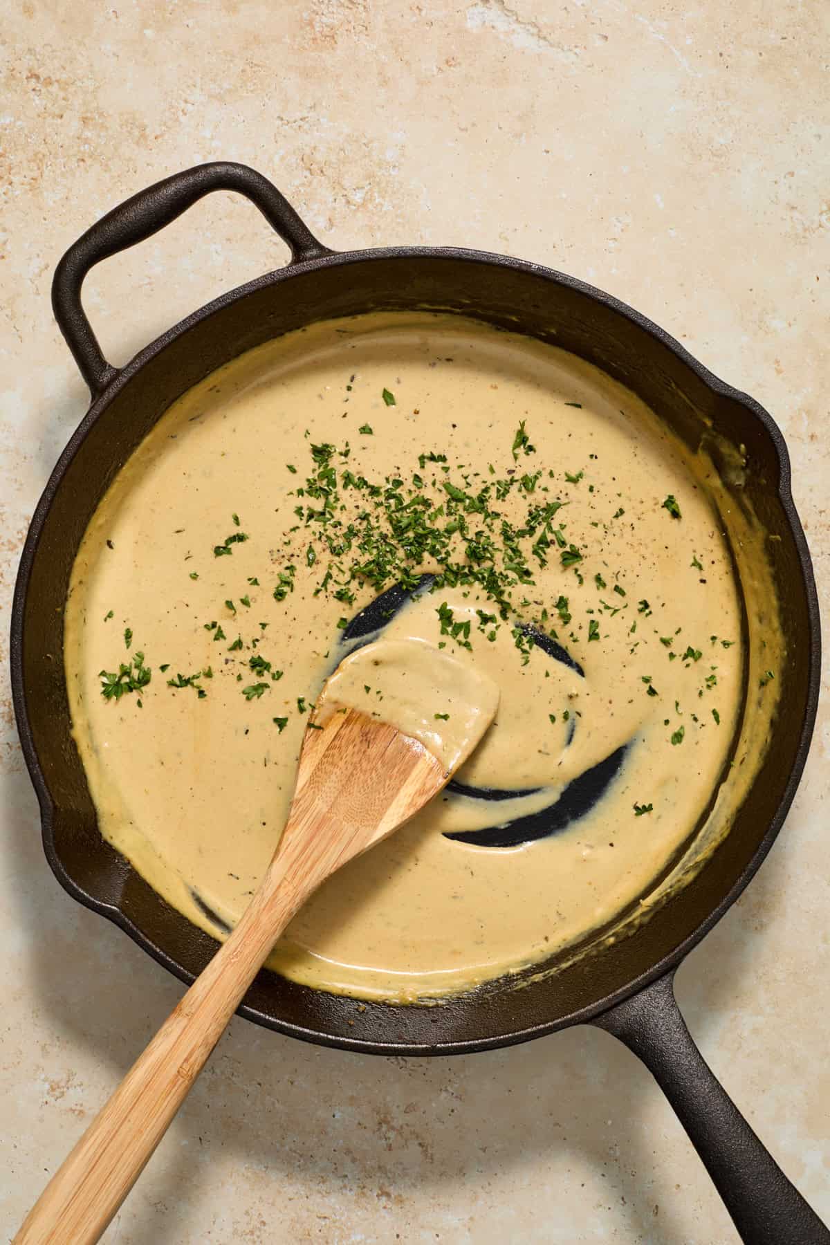 Creamy mustard sauce in skillet with parsley added in.