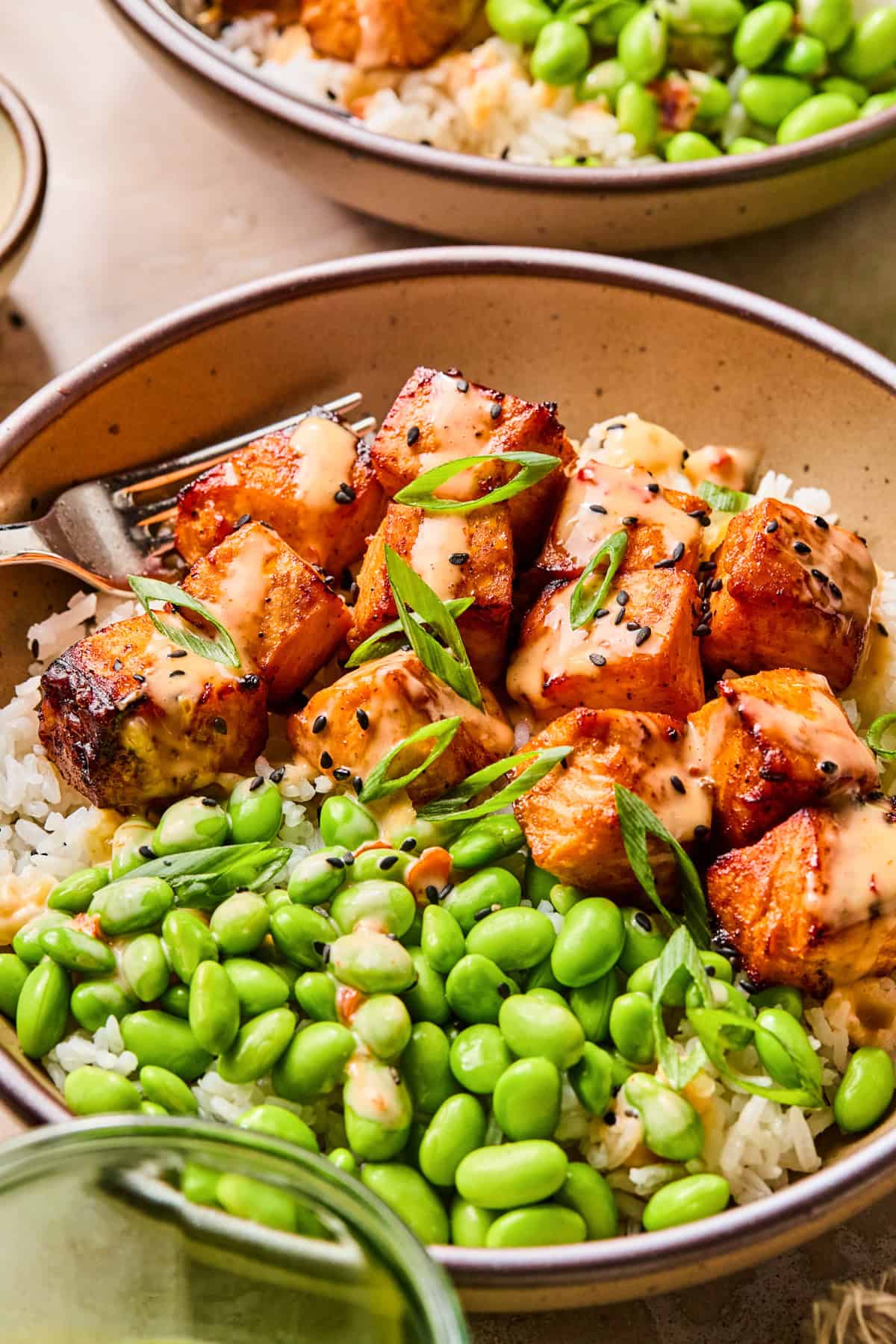 Dish with air fried salmon bites topped with bang bang sauce.