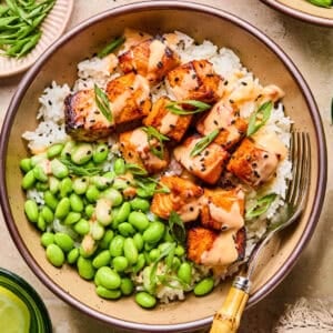 Air fryer salmon bites served with bang bang sauce over top and served on rice.