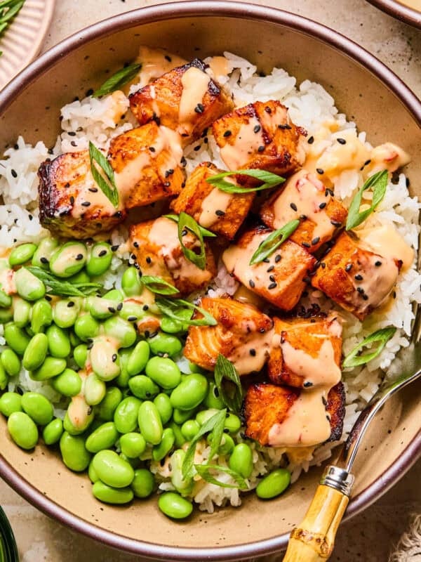 Air fryer salmon bites served with bang bang sauce over top and served on rice.
