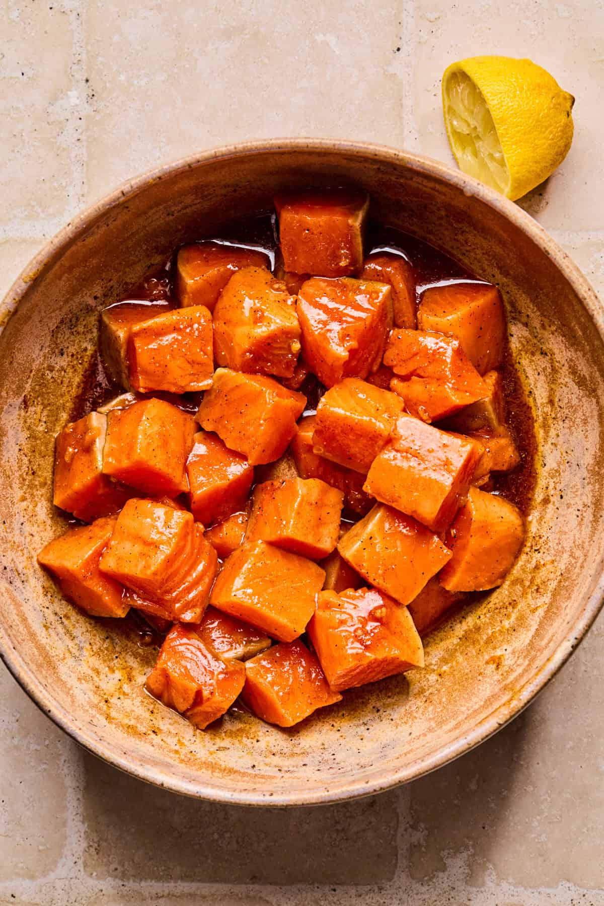 Salmon cubes in bowl with marinade.