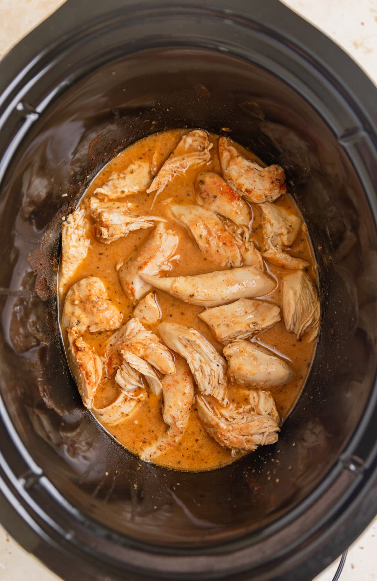 Crock pot honey mustard chicken pulled apart into pieces.