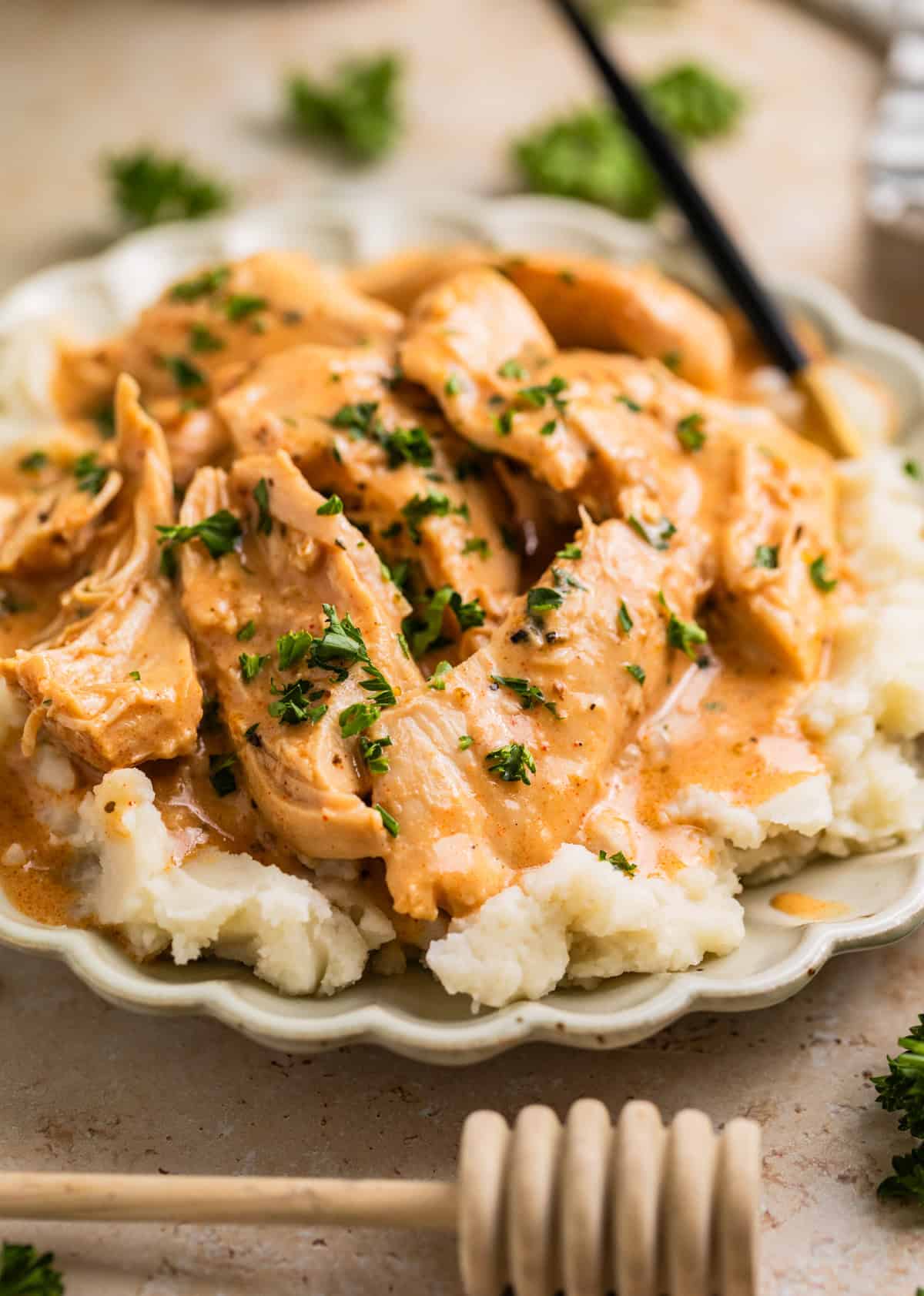 Creamy honey mustard chicken on top of mashed potatoes with chopped parsley.
