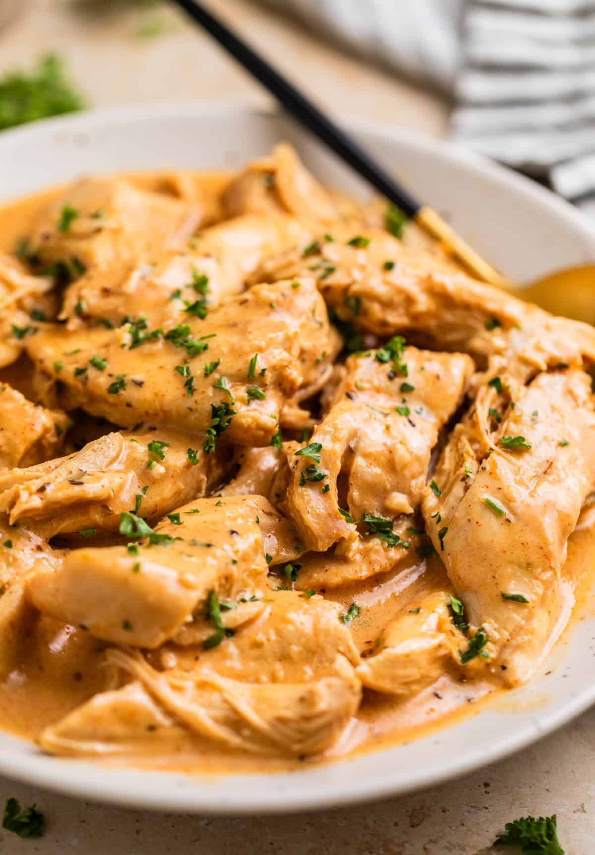 Creamy honey mustard chicken on plate with serving spoon.