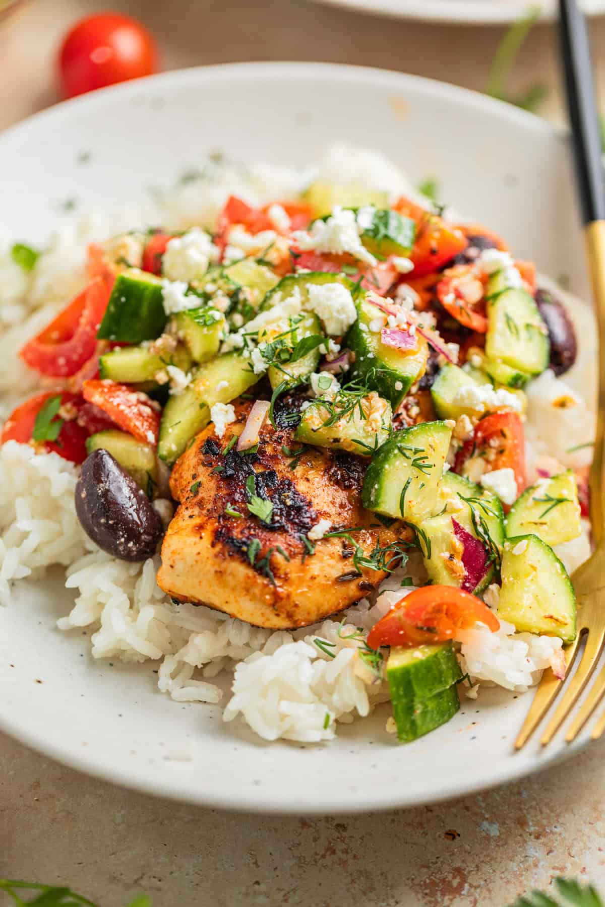 Grilled marinated mediterranean chicken on rice topped with greek cucumber salad.