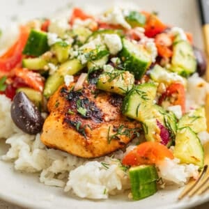 Mediterranean chicken served over rice and topped with cucumber salad.