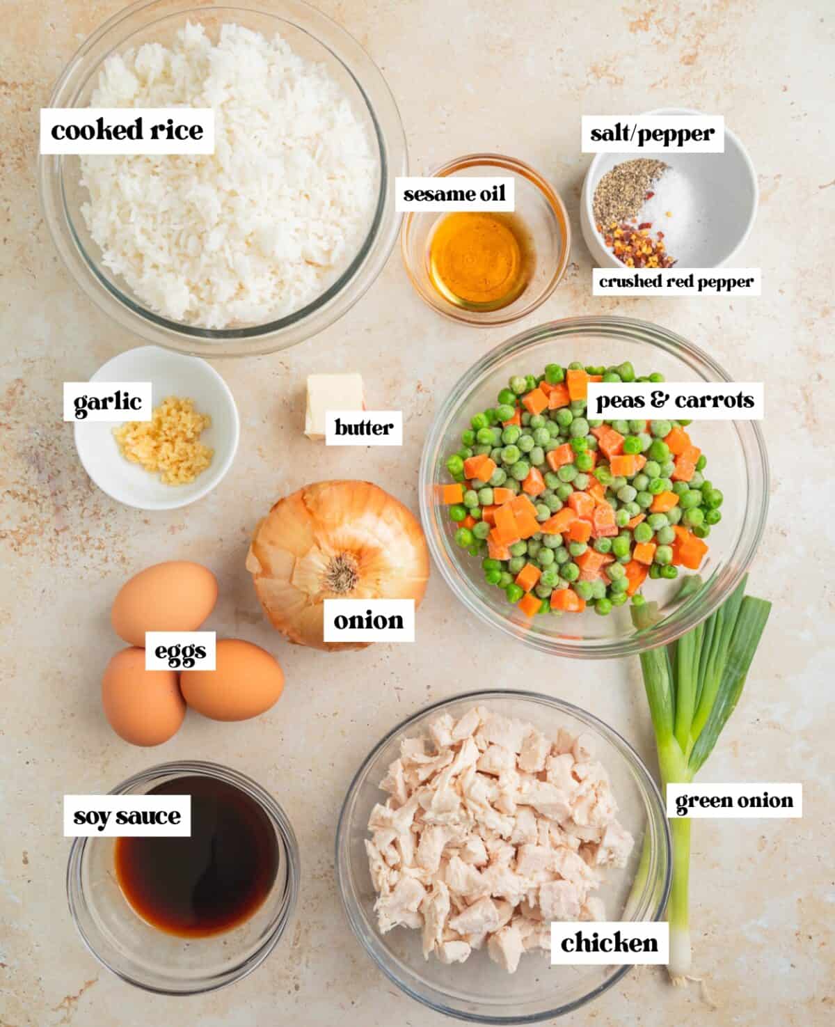 Cooked white rice, frozen peas and carrots and other ingredients arranged on surface and labeled.