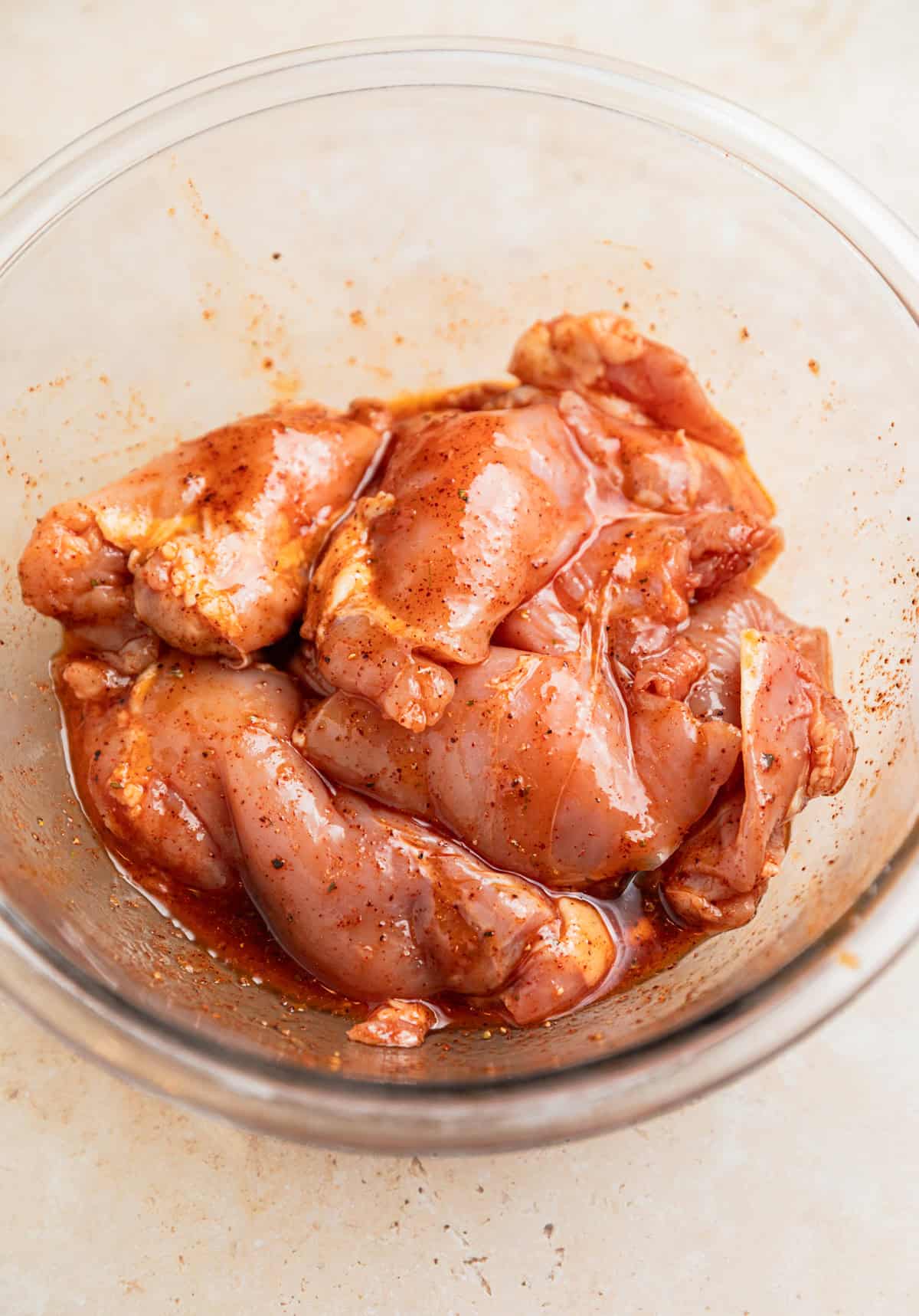 Chicken thighs in bowl with marinade.