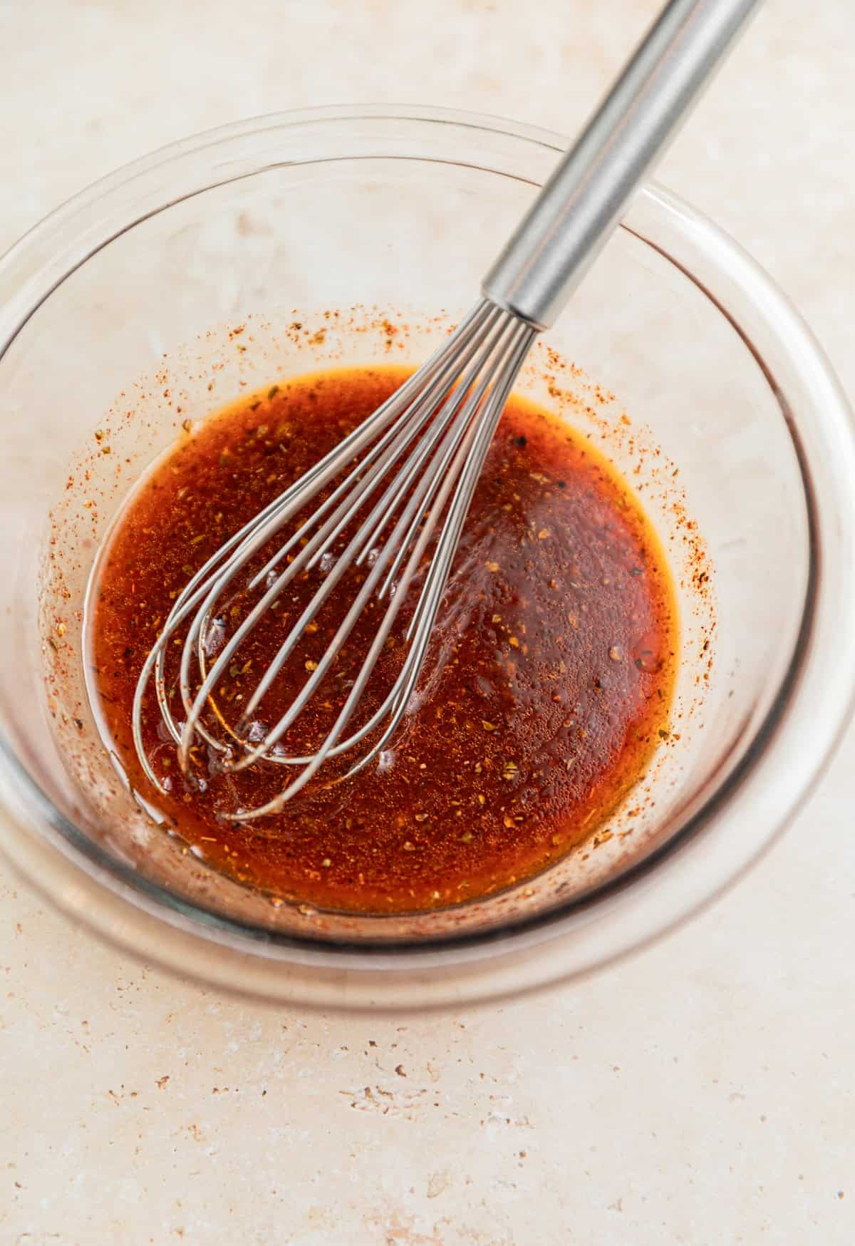 Chili lime marinade in glass mixing bowl with whisk.