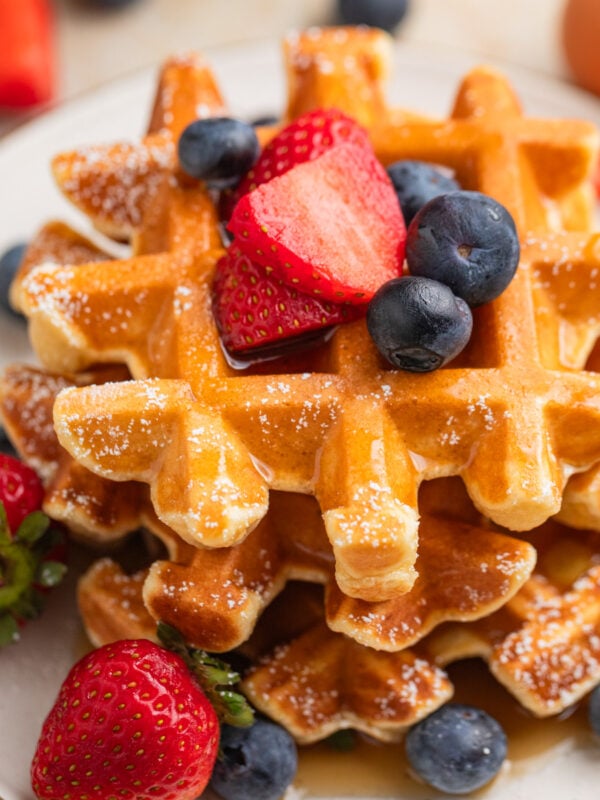 Cottage cheese waffles stacked on plate with berries.