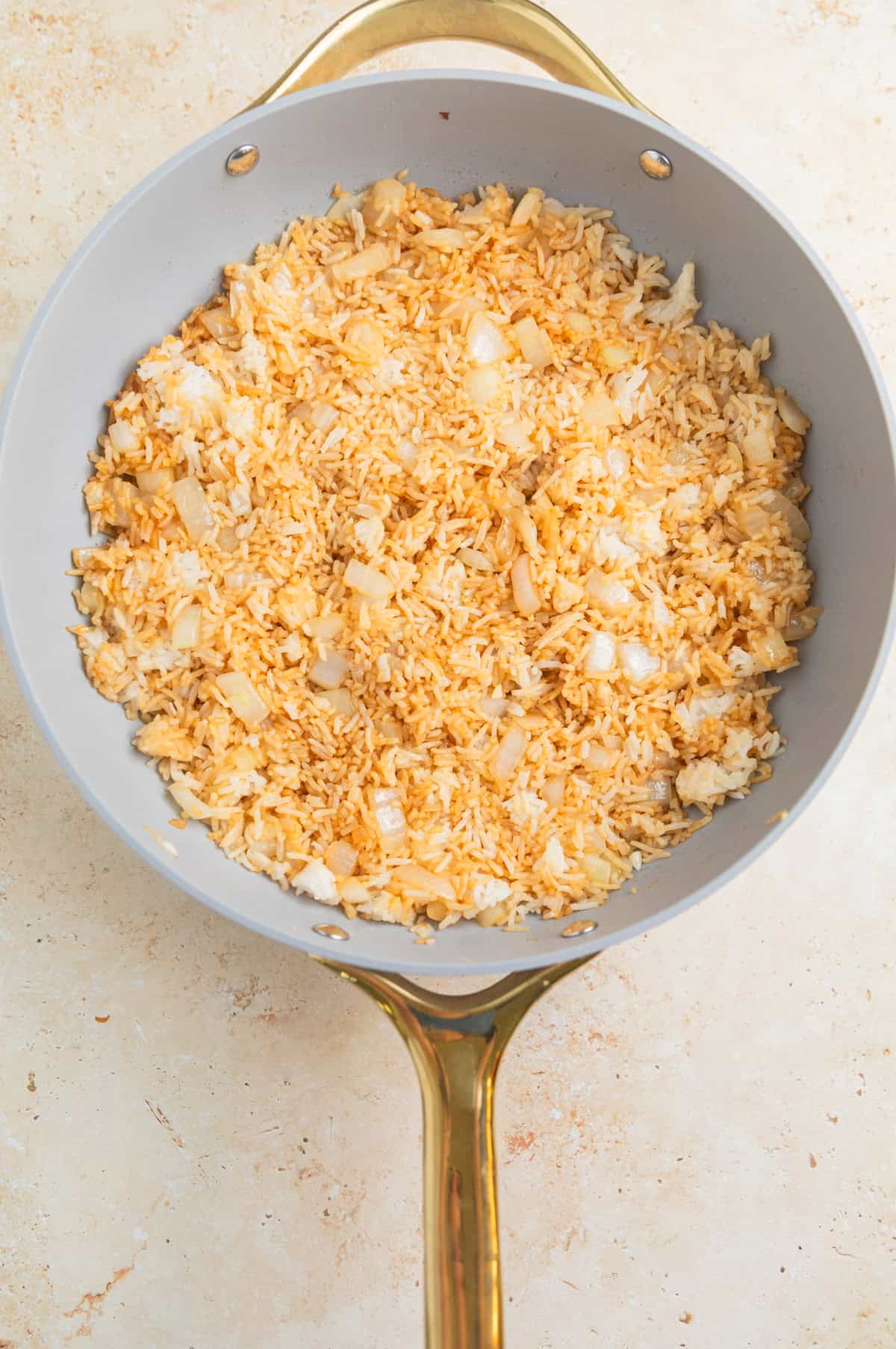 Soy sauce and sesame oil in skillet with rice.